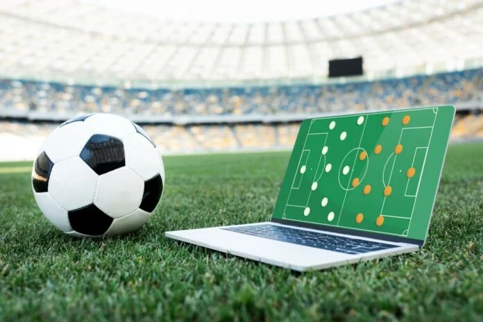 Fodbold og laptop med taktik på stadion